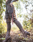 Rugged lace-up ankle boots in brown suede with stitched toe and eyelet details in a forest path
