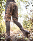 Brown leather lace-up ankle boots with stitched uppers and rugged finish, worn with dark jeans outdoors