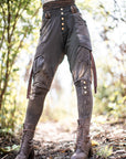 Dark cargo trousers with snap-button pockets, worn with brown lace-up leather boots outdoors