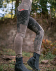 Outdoor unbranded black slip-on boots with textured sole and side straps in a garden