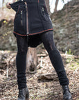 Black cargo shorts with zip pockets and red piping, outdoors with denim-like texture and rugged look