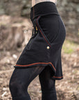 Close-up black utility pants in black fabric with red contrast stitching and a front zipper pocket
