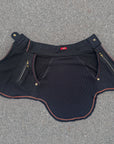 Black street cycling shorts with red piping and zip pockets, ribbed waistband detail on gray asphalt