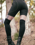 Everyday unbranded riding breeches in black fabric with contrast yellow stitching in an outdoor setting