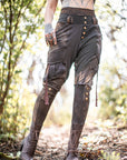 Rugged cargo pants in charcoal brown with buttoned cuffs and drawstring hem ties in outdoor light