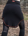 Ribbed unbranded compression socks in black knit with orange-trimmed cuff and red logo patch.