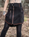 Distressed black denim skirt with gold-tone zippers and orange edge stitching details