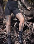 Unbranded black biker shorts with contrast stitched seams and rolled hem in outdoor rock setting