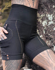 Men's black jogger pants with contrast tan stitching and snap-button cuffs outdoors