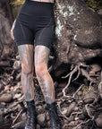 Sleek Brandless black high-waisted shorts with contrast stitched seams, worn with lace-up boots in rocky outdoors